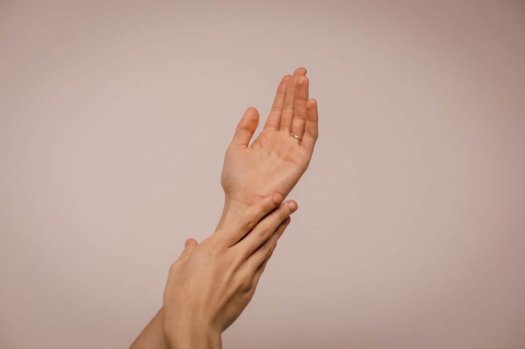 Two arms of a person rubbing against each other - benefits of multivitamins for skin